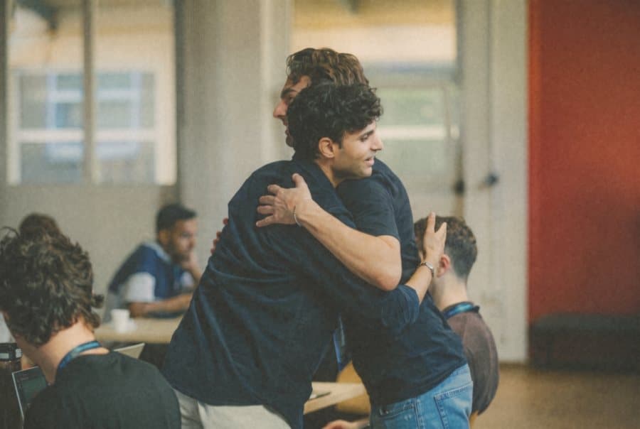 Un abbraccio fra partecipanti a un hackathon