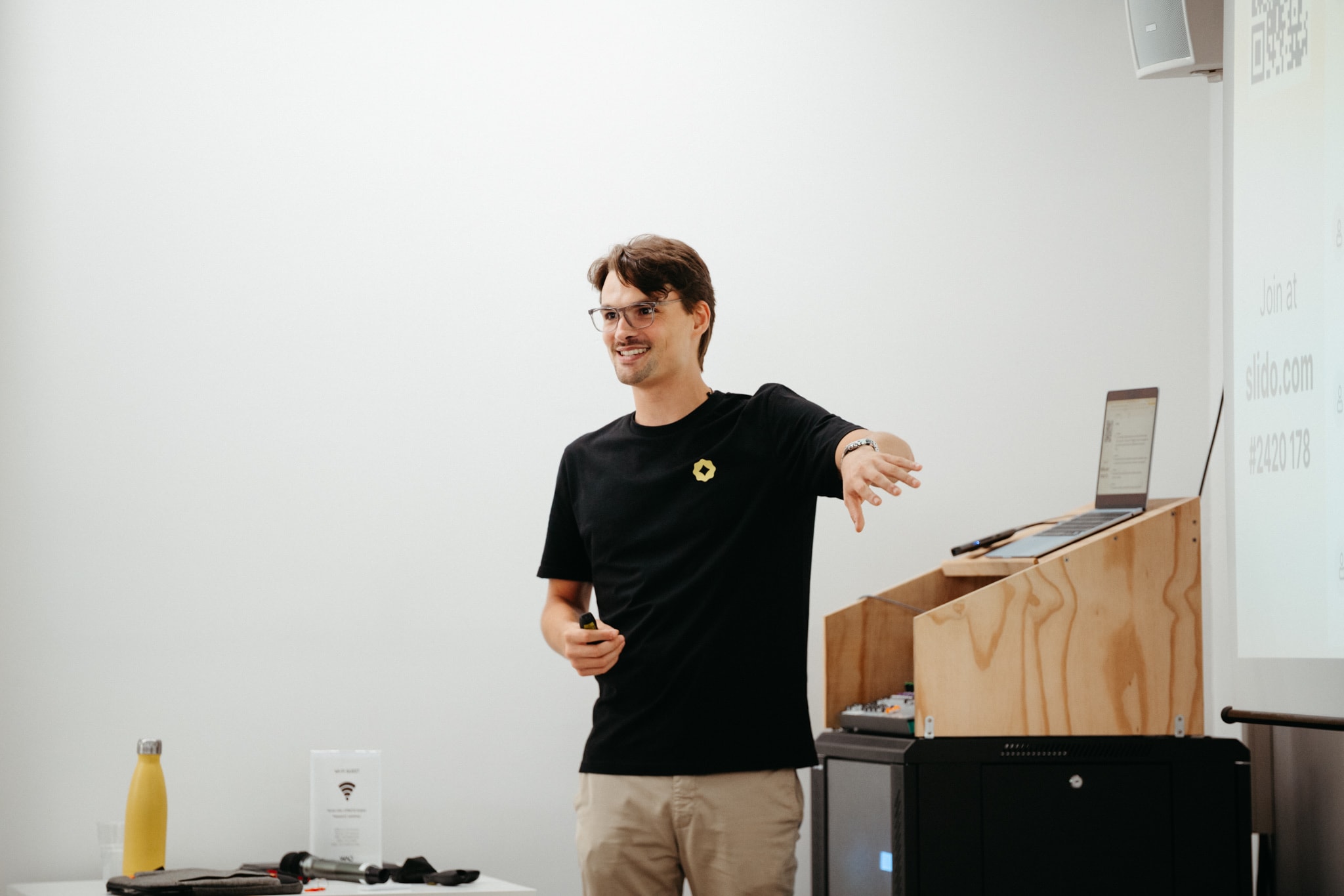 Un formatore Yellow Tech parla alla sala durante una sessione di formazione, accanto al leggìo con il portatile
